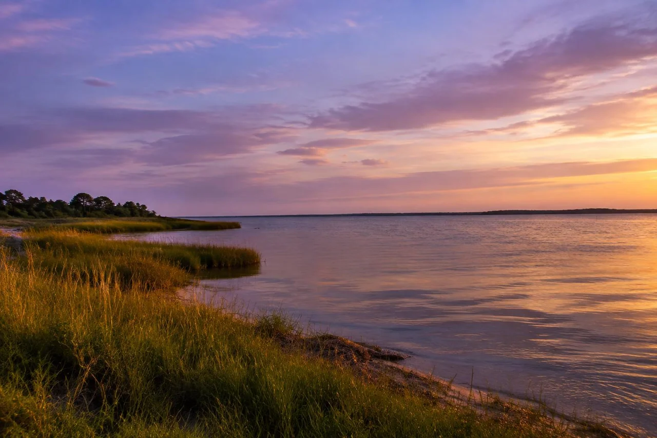 Calm Chesapeake Bay shoreline beneath a lavender dusk sky